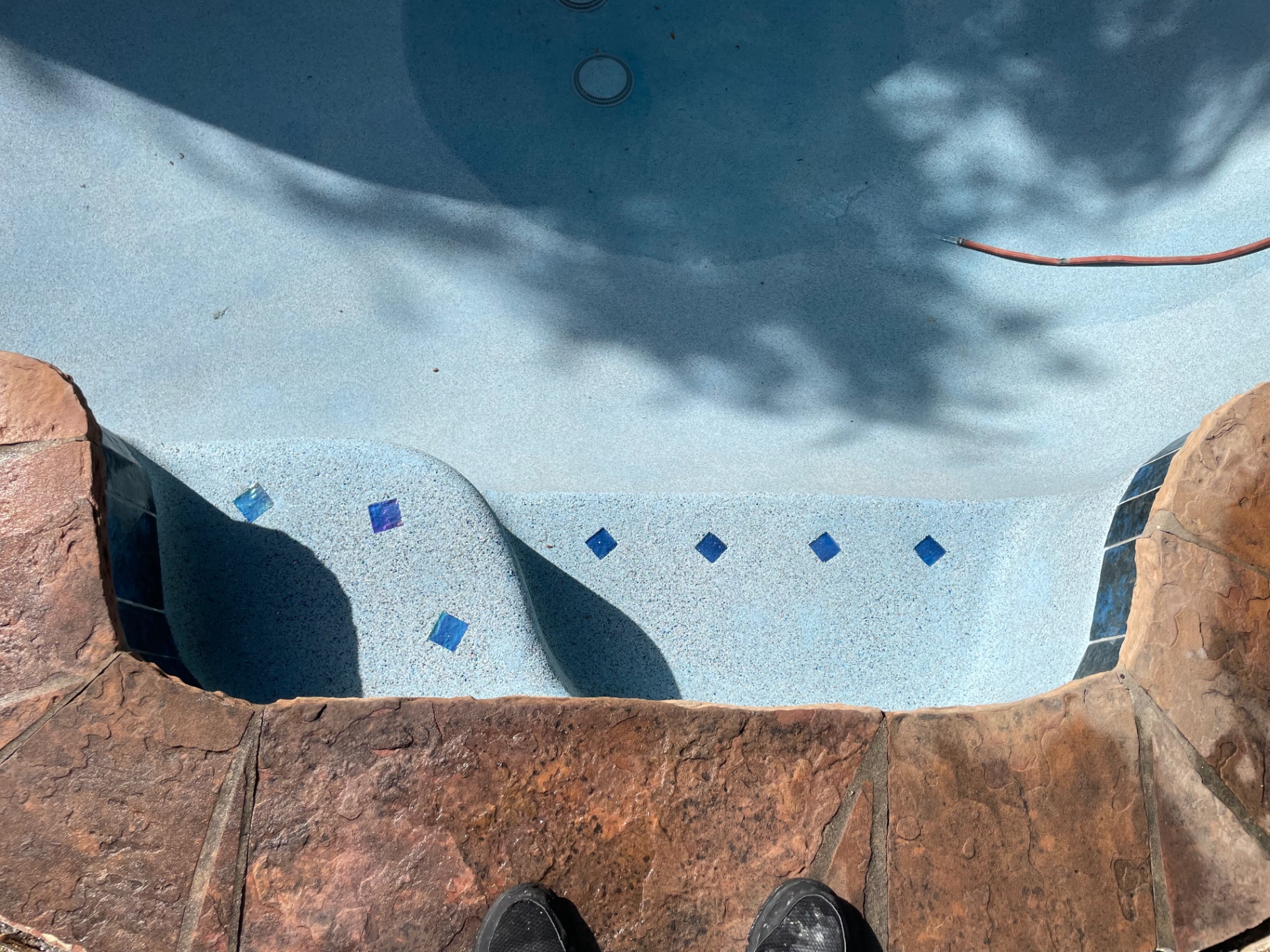 Detail of pool entry steps with cobalt blue glass tile accents and flagstone coping