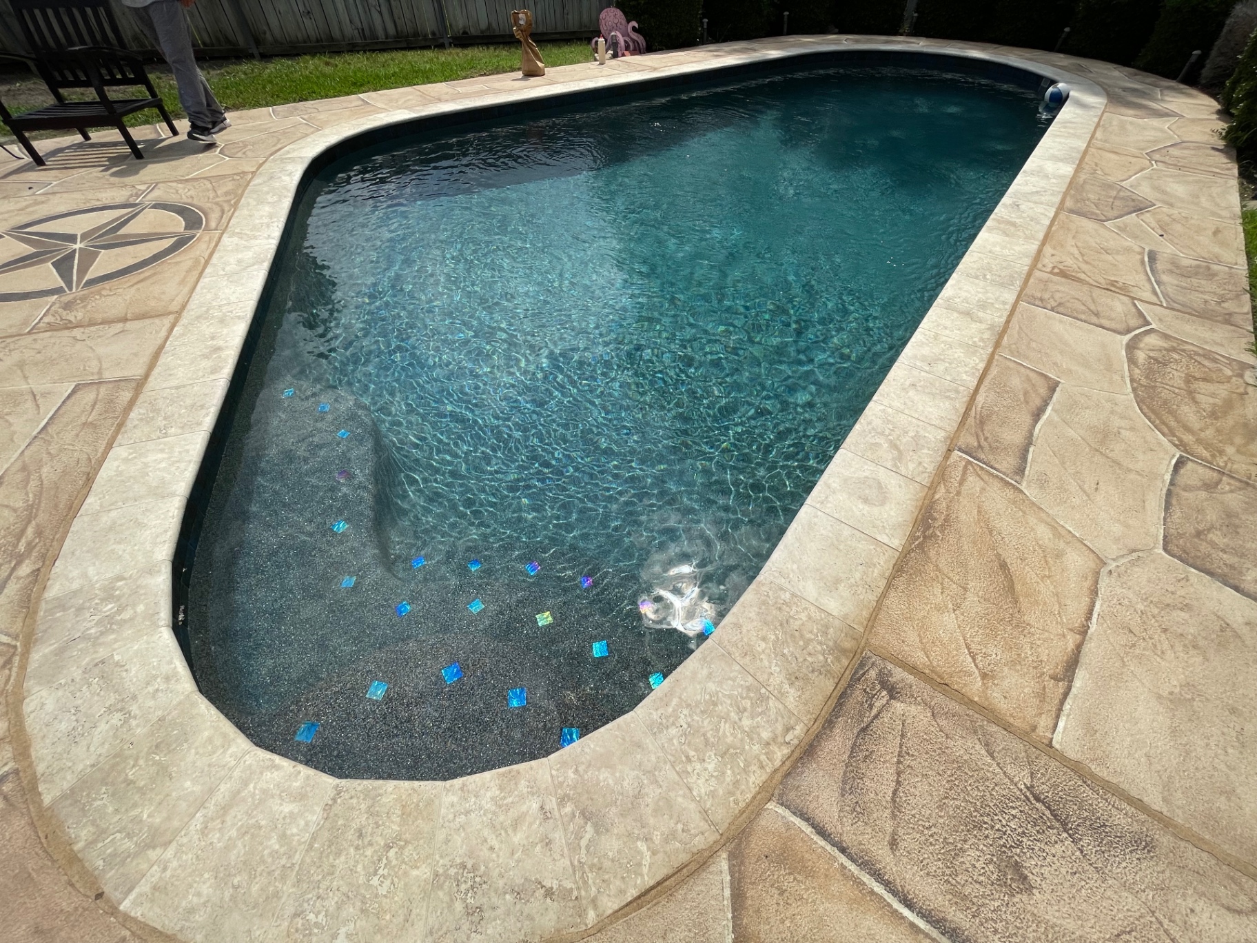 Finished Roman pool filled with sparkling water and glass tile accents
